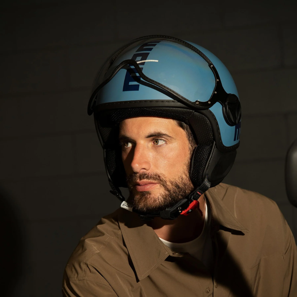 Uomo indossa il casco jet Momo Design FGTR Classic blu polvere opaco, vista di tre quarti