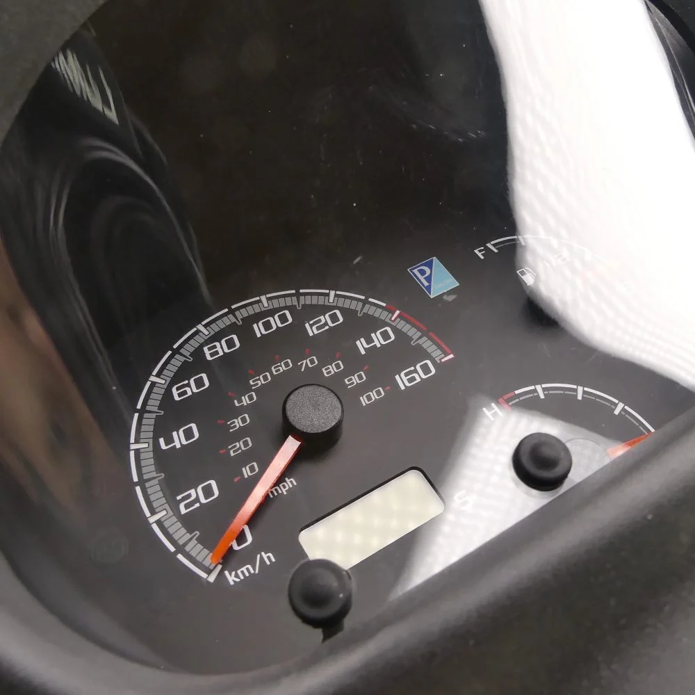 Dettaglio del tachimetro del quadro strumenti Piaggio Porter Multitech E6 1D000816: doppia scala 20-160 km/h e 10-100 mph con lancetta rossa e display LCD a segmenti