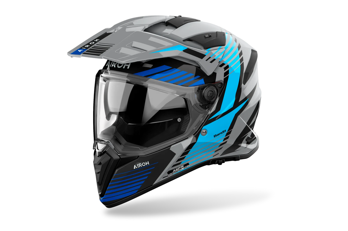 Airoh Bandit BADX-X Spicy Blu Lucido (BAS18), casco adventure visto di tre quarti dal lato sinistro, grafica grigia e nera con inserti azzurri e blu, lucida
