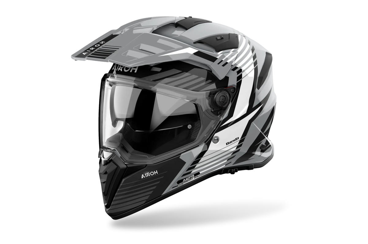 Airoh Bandit BADX-X Spicy Grigio Lucido (BAS16), casco adventure visto di tre quarti dal lato sinistro, grafica grigia, bianca e nera, lucida