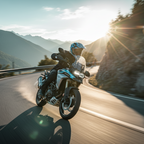 Motociclista con casco Airoh Commander 2 Mavick blu ceruleo in sella su una strada di montagna
