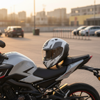 Casco Airoh Valor Wings bianco e nero appoggiato su una moto naked in un parcheggio al tramonto