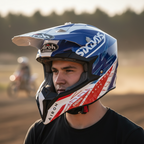 Ragazzo con il casco cross Airoh Wraap Six Days 2022 France blu, bianco e rosso a bordo pista