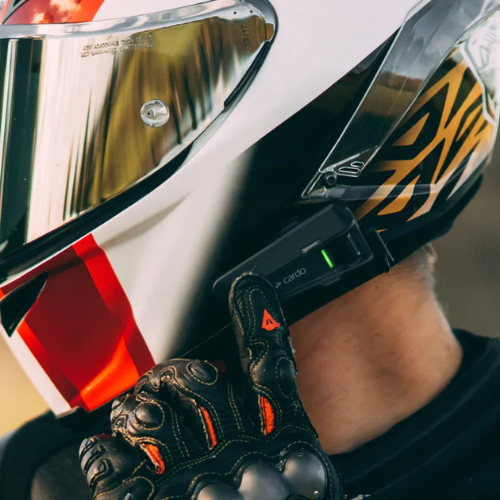 Motociclista con guanti e casco con interfono Cardo Packtalk Neo sulla calotta