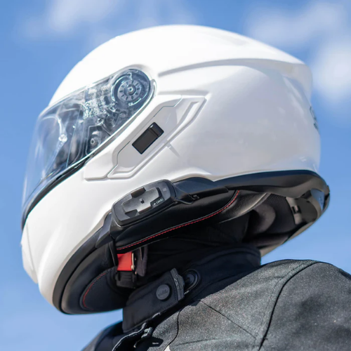 Casco Shoei bianco con interfono Cardo Packtalk-S integrato, vista laterale in strada