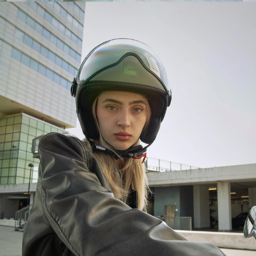 Casco jet Momo Design FGTR Classic Flip verde opaco indossato con occhialini, ambientazione urbana