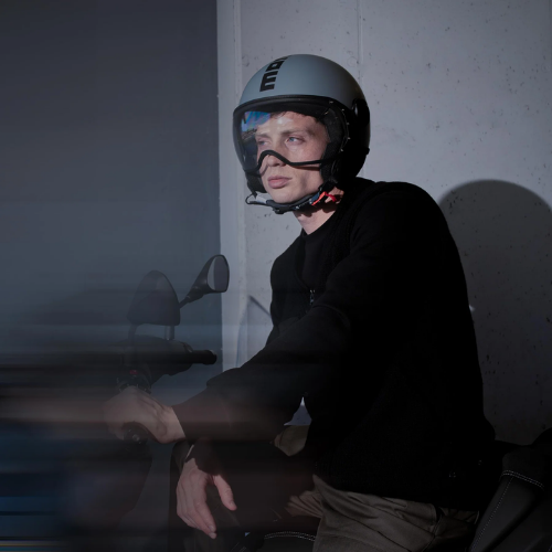 Motociclista con casco jet Momo Design FGTR Classic Mono grigio opaco in sella a uno scooter