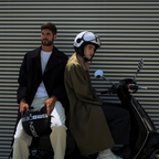 Casco jet Momo Design FGTR Classic Mono nero opaco con scritte bianche tenuto in mano, ambientazione di citta