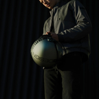 Dettaglio del casco jet Momo Design FGTR EVO Mono titanio opaco tenuto in mano, con la scritta MOMODESIGN