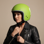Donna con giacca in pelle nera indossa il casco jet Vespa Colors verde opaco, vista laterale