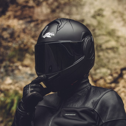 Casco modulare flip-back Kappa KV55 Nero Opaco, indossato di profilo su strada di montagna, casco chiuso