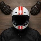 Casco integrale Vespa Racing Sixties bianco su tavolo di legno accanto a guanti e giacca in pelle