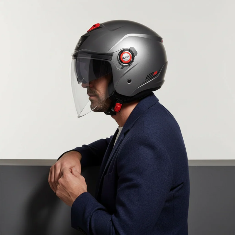 Uomo di profilo con il casco jet Givi 12.5 titanio opaco e la visiera trasparente abbassata