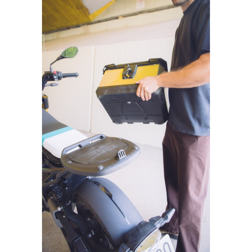 Bauletto Kappa in alluminio verniciato giallo sganciato a mano dalla piastra posteriore di uno scooter