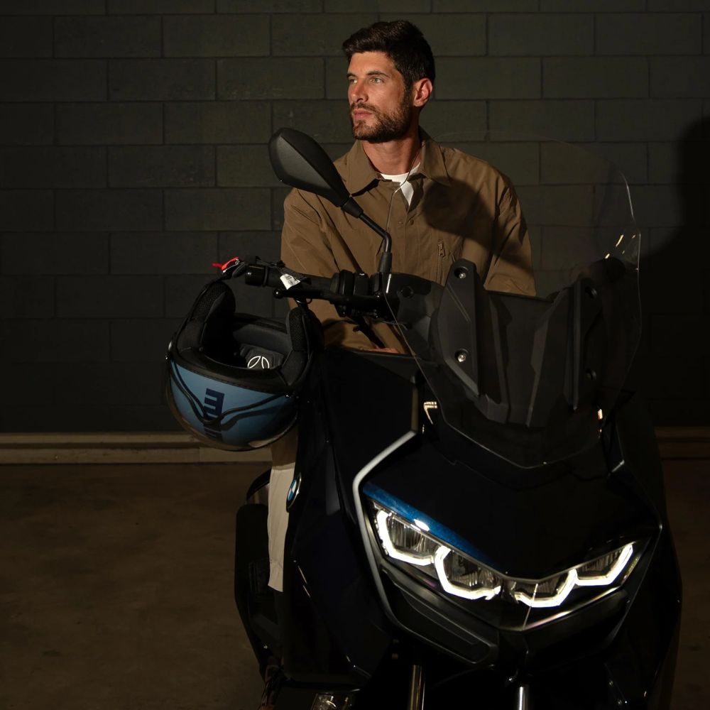 Casco jet Momo Design FGTR Classic blu polvere opaco appoggiato allo specchietto di uno scooter