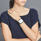 Ragazza in maglia blu che indossa il Momo Design Stealth al polso, quadrante analogico chiaro