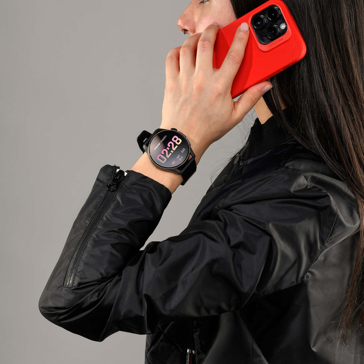 Donna in giacca di pelle nera al telefono con l'orologio Momo Design Zero al polso