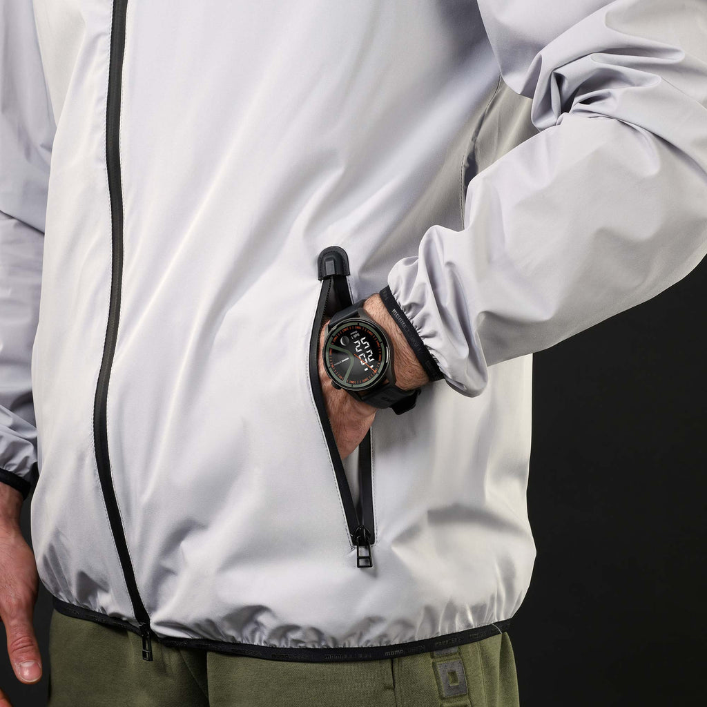 Uomo con giacca chiara e mano in tasca che indossa l'orologio rotondo Momo Design Zero nero