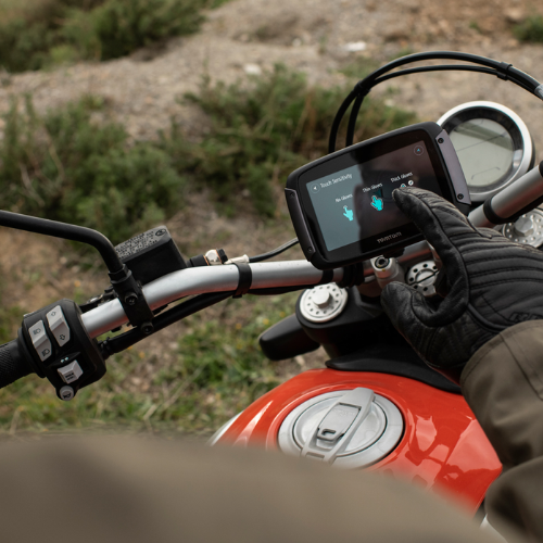 TomTom Rider 550 montato sul manubrio di una moto mentre il pilota tocca lo schermo con i guanti